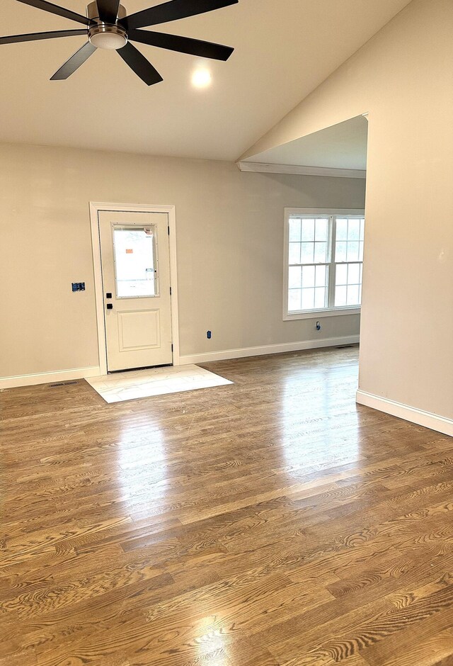 interior space featuring baseboards, wood finished floors, a ceiling fan, and vaulted ceiling