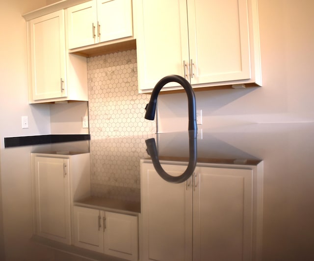 room details featuring dark countertops and white cabinetry