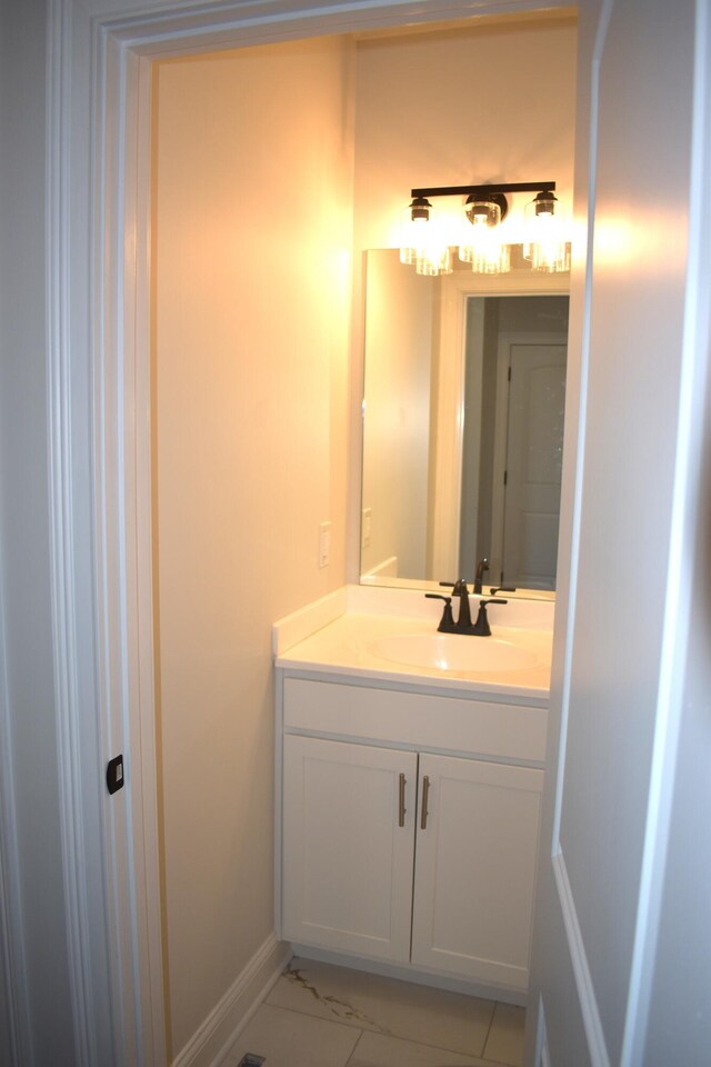 bathroom with marble finish floor, vanity, and baseboards