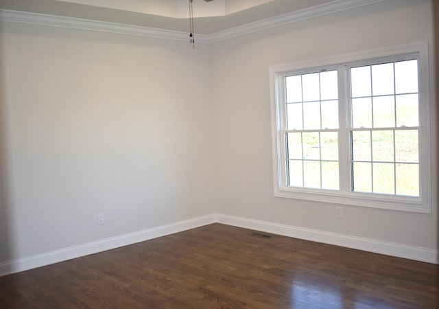 unfurnished room with dark wood-type flooring, visible vents, ornamental molding, and baseboards