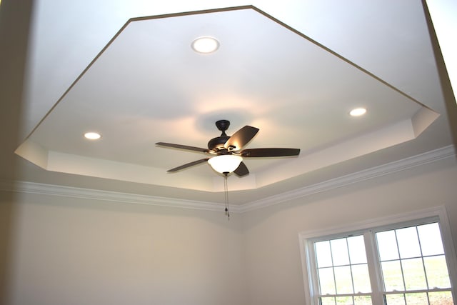 interior details with recessed lighting, a ceiling fan, and a tray ceiling