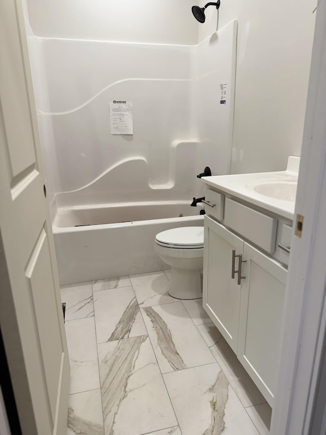bathroom with toilet, marble finish floor, washtub / shower combination, and vanity