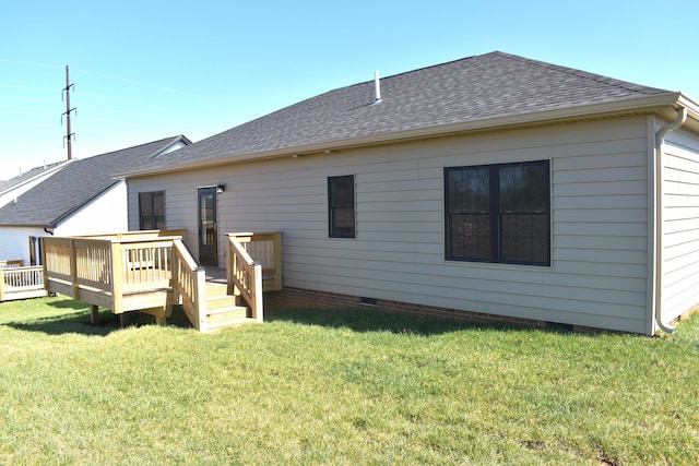 back of property featuring roof with shingles, a deck, a yard, and crawl space
