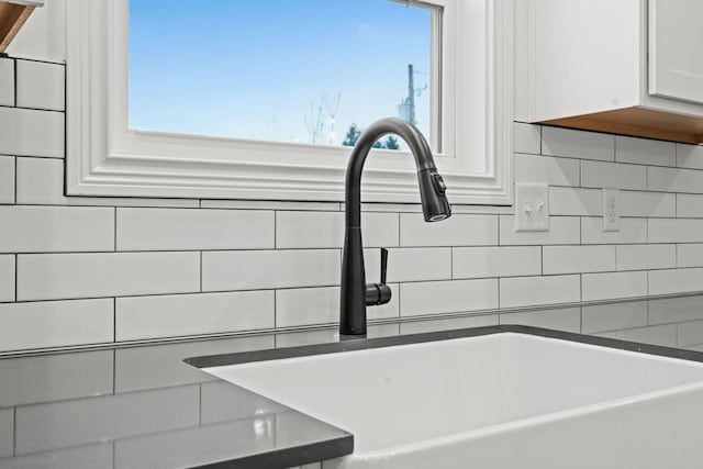 interior details featuring white cabinetry and a sink