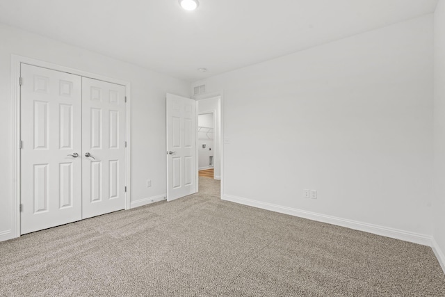 unfurnished bedroom featuring visible vents, a closet, baseboards, and carpet flooring