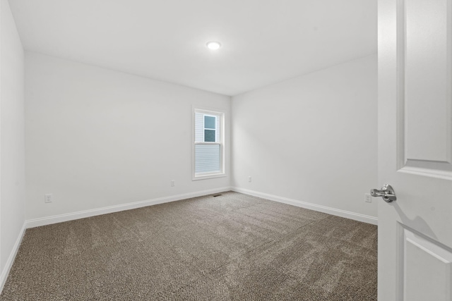 carpeted empty room with visible vents and baseboards