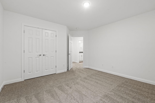 unfurnished bedroom with carpet floors, a closet, and baseboards