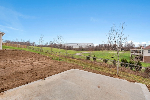 view of yard with a rural view, a patio, and fence