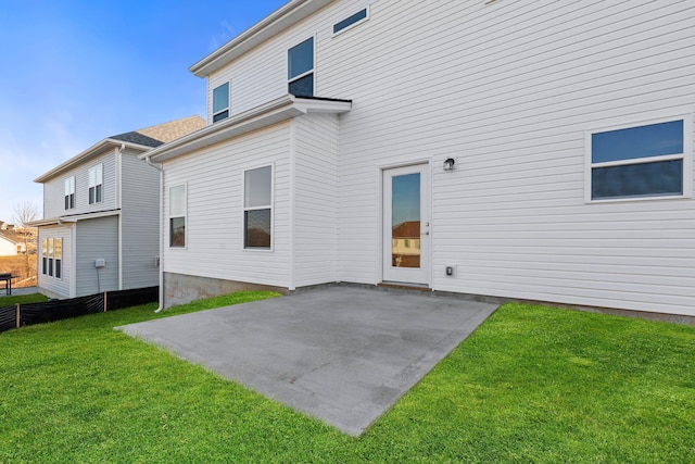 rear view of property with a lawn and a patio