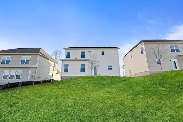 rear view of property featuring a lawn