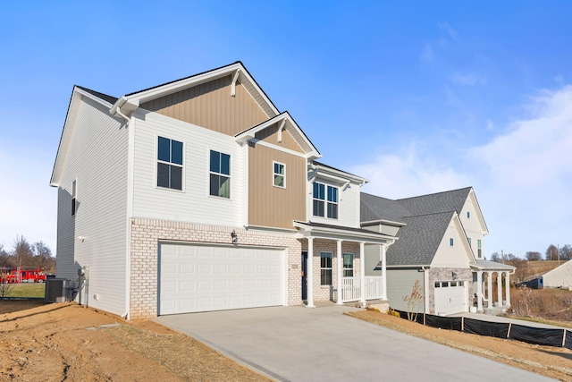 traditional-style home with driveway, a garage, covered porch, central AC, and brick siding