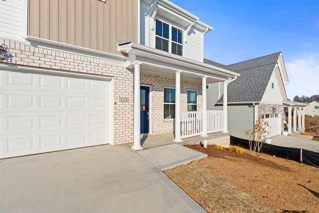 view of front of property featuring concrete driveway, an attached garage, a porch, board and batten siding, and brick siding