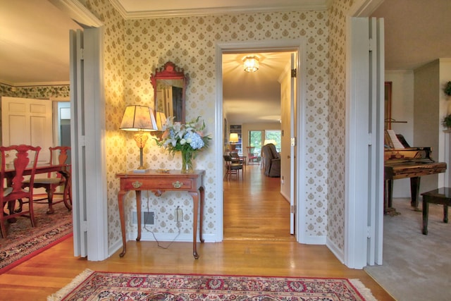 corridor with ornamental molding and light wood-type flooring