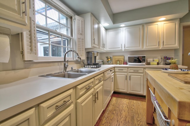 kitchen featuring dishwasher, light wood-type flooring, wood counters, and sink