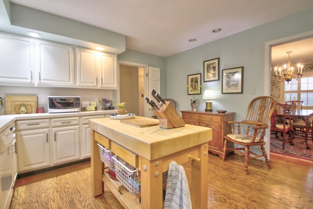 kitchen featuring decorative light fixtures, white cabinetry, light hardwood / wood-style flooring, and an inviting chandelier