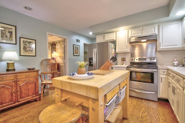 kitchen with white cabinets, stainless steel appliances, and light hardwood / wood-style floors