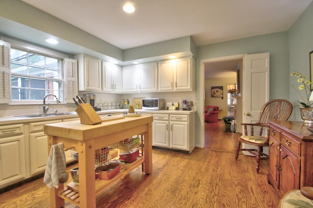 kitchen with white cabinetry, sink, and light hardwood / wood-style floors