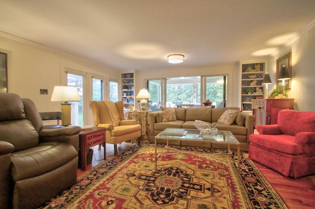 living room featuring built in features, wood-type flooring, and ornamental molding