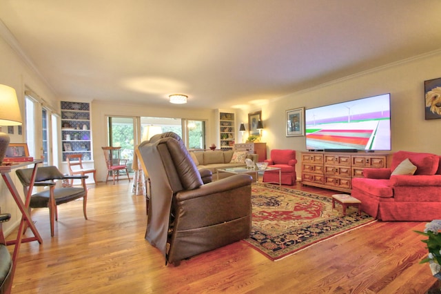 living room with built in shelves, light hardwood / wood-style flooring, and ornamental molding