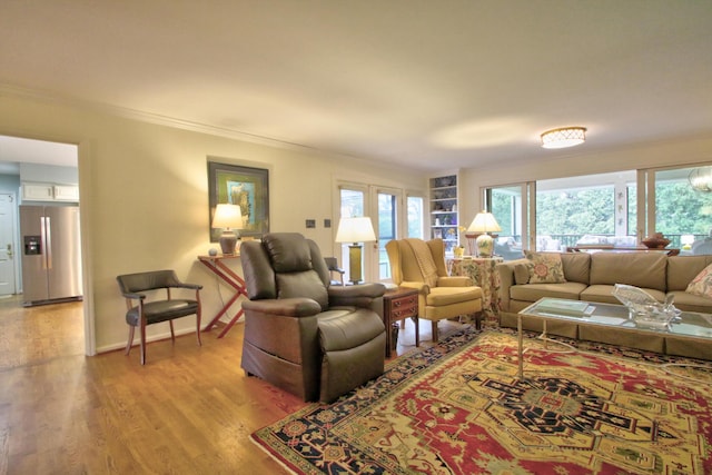 living room featuring crown molding and light hardwood / wood-style flooring