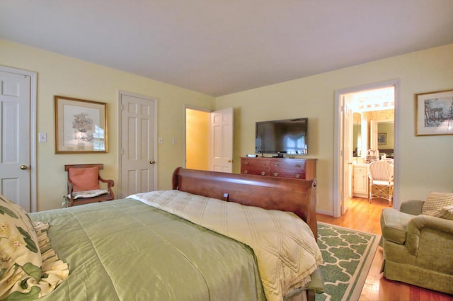 bedroom featuring connected bathroom and light wood-type flooring