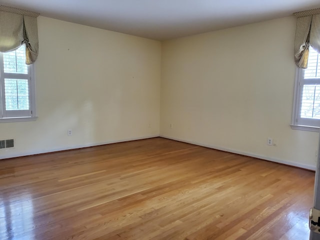 unfurnished room featuring light hardwood / wood-style floors and a wealth of natural light