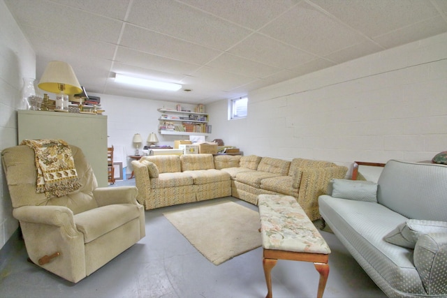 living room with a drop ceiling and concrete floors