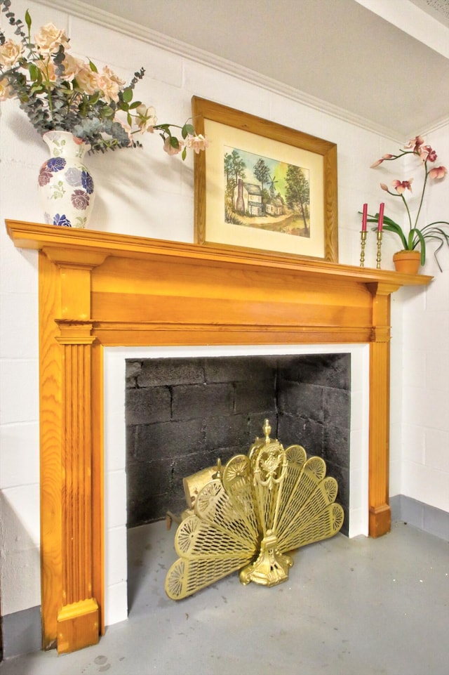 room details featuring a fireplace, concrete floors, and crown molding