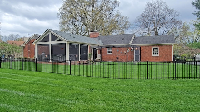 back of house with a lawn and a sunroom