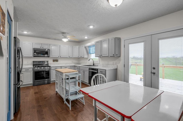 kitchen featuring french doors, sink, stainless steel appliances, dark hardwood / wood-style floors, and a textured ceiling