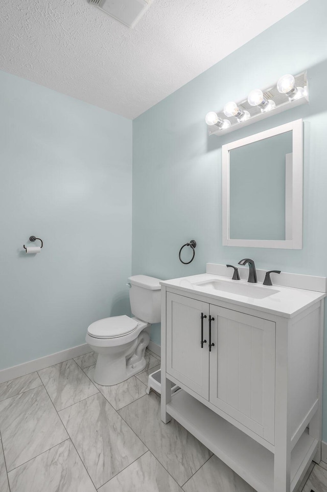 bathroom with vanity, a textured ceiling, and toilet