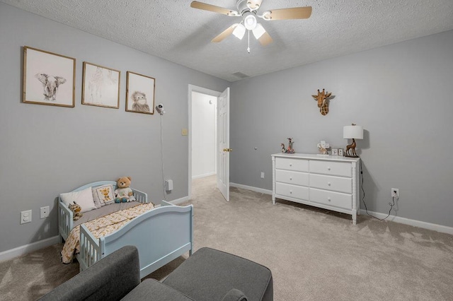 carpeted bedroom featuring ceiling fan and a textured ceiling