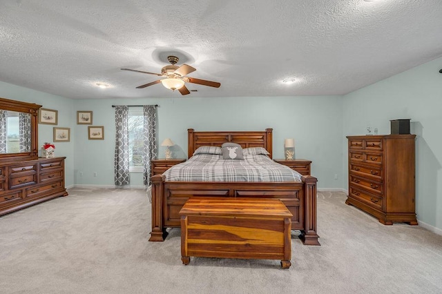 carpeted bedroom with ceiling fan and a textured ceiling