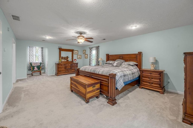 carpeted bedroom with a textured ceiling and ceiling fan