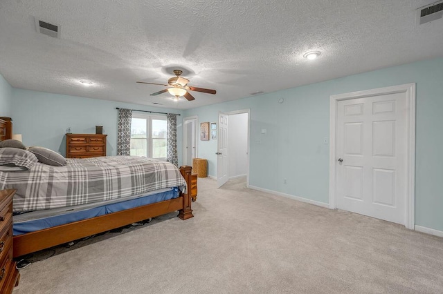 carpeted bedroom with ceiling fan and a textured ceiling