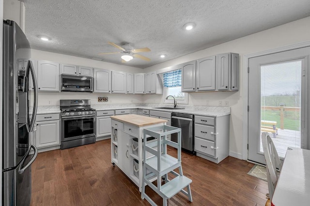 kitchen featuring gray cabinets, dark hardwood / wood-style flooring, sink, and appliances with stainless steel finishes