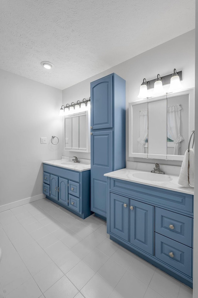 bathroom featuring tile patterned floors, vanity, and a textured ceiling