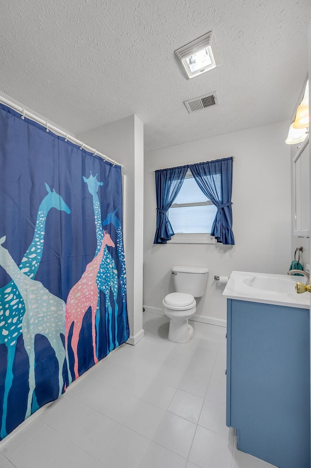 bathroom with vanity, toilet, and a textured ceiling