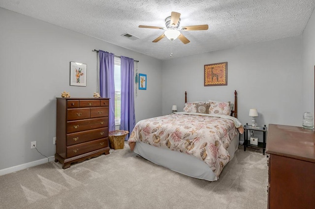 bedroom with ceiling fan, light carpet, and a textured ceiling