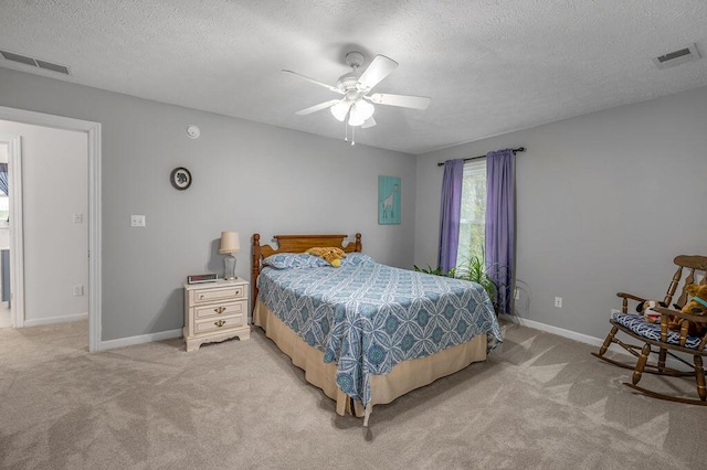 carpeted bedroom featuring ceiling fan and a textured ceiling