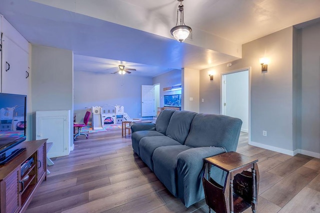 living room featuring ceiling fan and light wood-type flooring