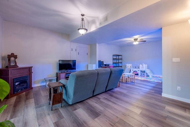 living room with ceiling fan and light wood-type flooring