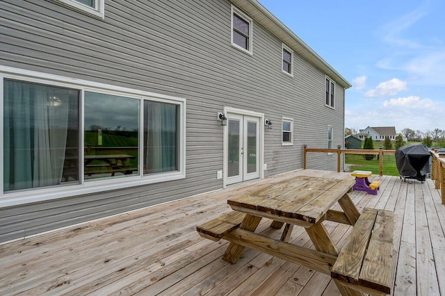 wooden terrace with a grill and french doors