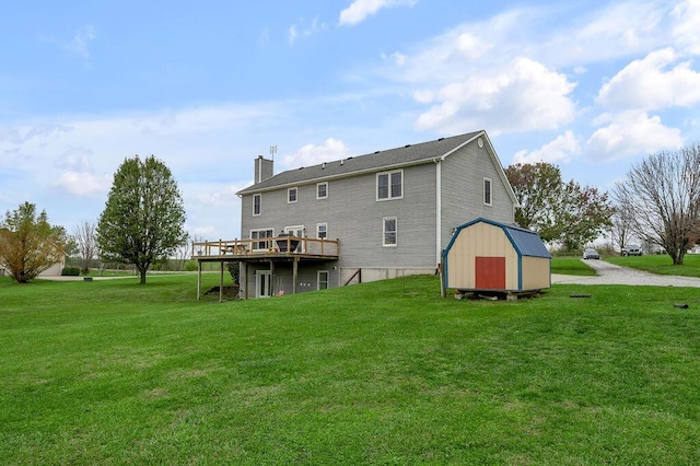 back of property with a wooden deck, a yard, and a shed