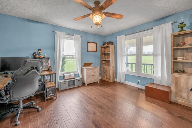 office space featuring ceiling fan, dark hardwood / wood-style flooring, and a textured ceiling