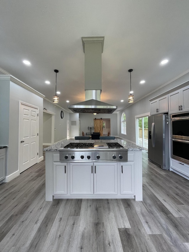 kitchen with hanging light fixtures, light stone countertops, white cabinetry, island exhaust hood, and stainless steel appliances