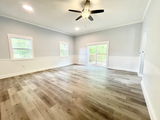 empty room with ceiling fan, light wood-type flooring, and ornamental molding