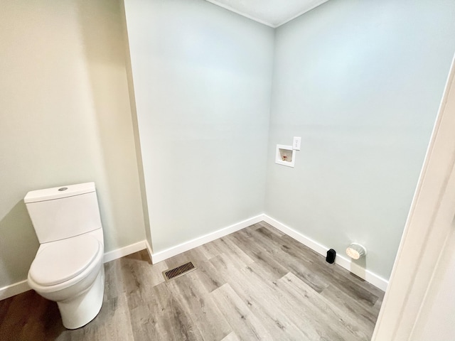 bathroom with hardwood / wood-style floors and toilet