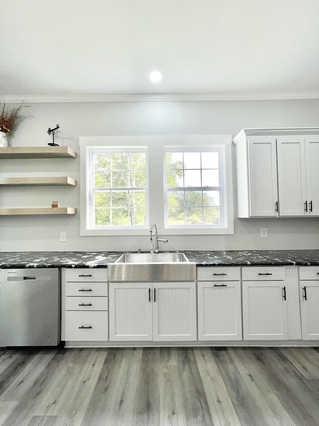 kitchen featuring white cabinetry, stainless steel dishwasher, a wealth of natural light, and crown molding