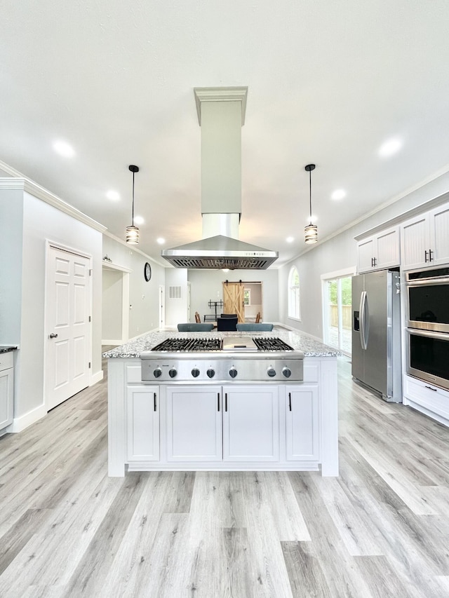 kitchen featuring light stone countertops, hanging light fixtures, stainless steel appliances, island exhaust hood, and crown molding